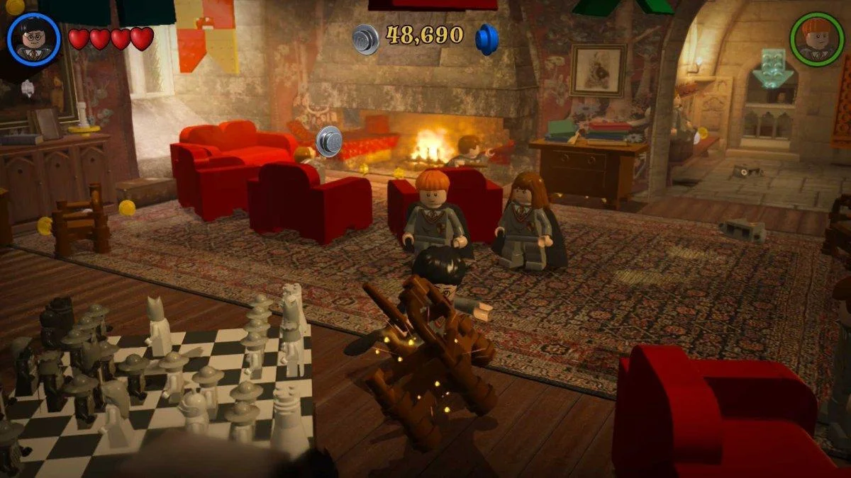Gameplay screenshot of LEGO Harry Potter Collection on Nintendo Switch 2 showing Harry, Ron, and Hermione in the Gryffindor common room