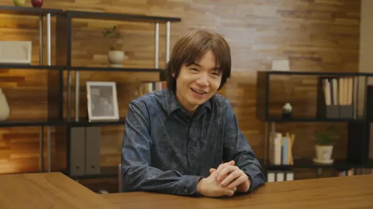 Masahiro Sakurai smiling at a desk during an official Nintendo presentation