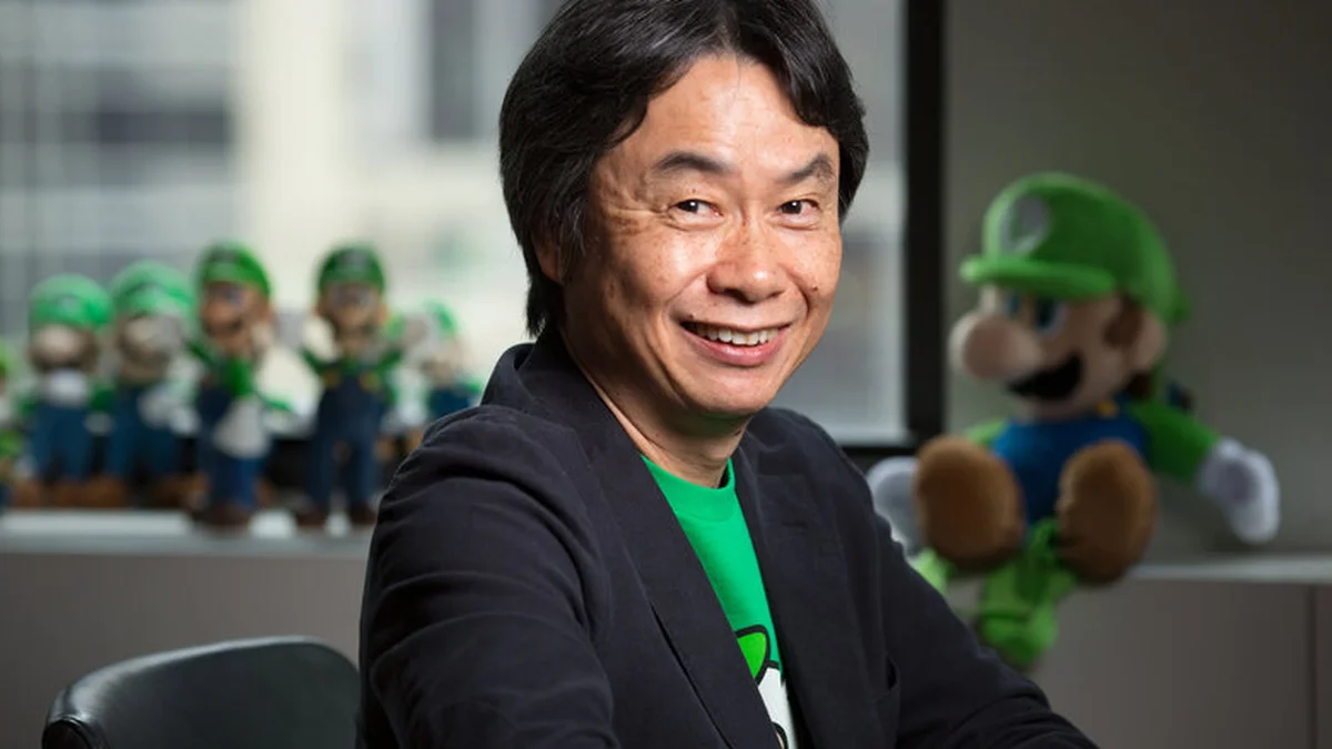 Shigeru Miyamoto smiling in front of Luigi plushies at Nintendo